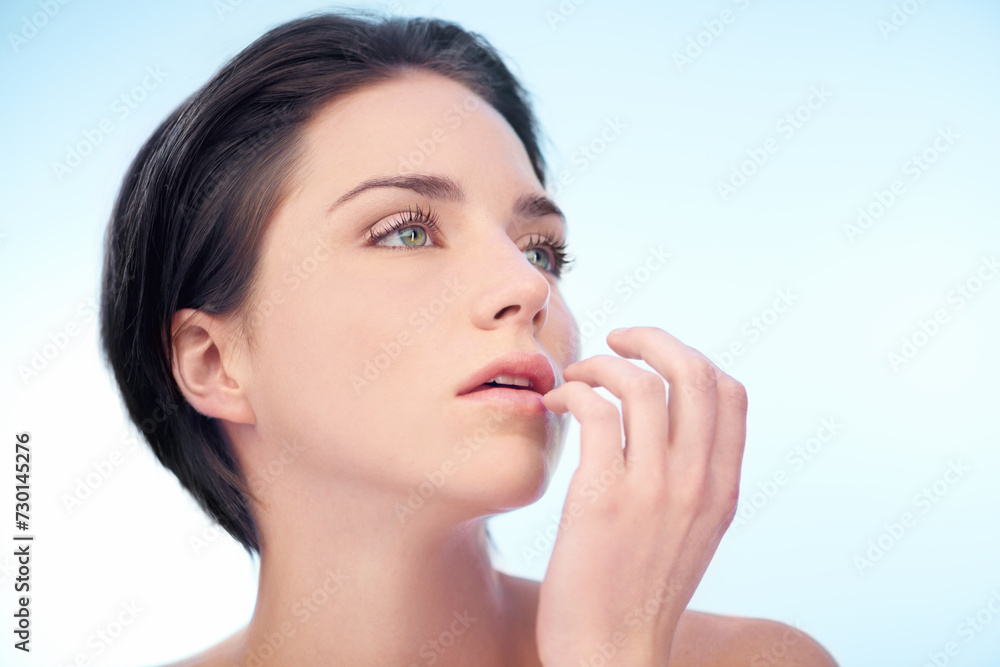 Woman, beauty and thinking or lips for wellness in studio for cosmetic on blue background, mockup space or dermatology. Female person, model and hand with thoughts or touching mouth, skincare or glow Woman, beauty and thinking or lips for wellness in studio for cosmetic on blue background, mockup space or dermatology. Female person, model and hand with thoughts or touching mouth, skincare or glow