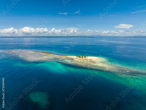 Drone shot of White sand beach Hagonoy Island. Blue sea water under skyline. Britania Group of Islands. Mindanao, Philippines.