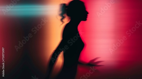 Female silhouette on a red gradient background. Elegant outline of a woman in motion out of focus