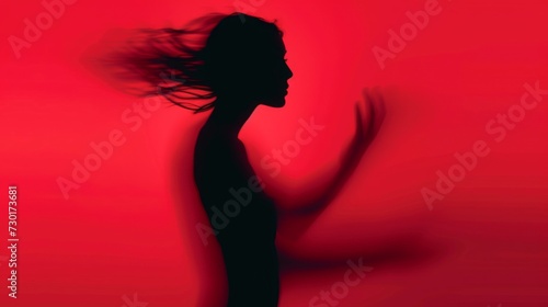 Female blurred silhouette on a red background. Elegant outline of a woman in motion out of focus