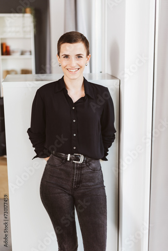Confident Young Woman with Short Hair Smiling in Office Environment