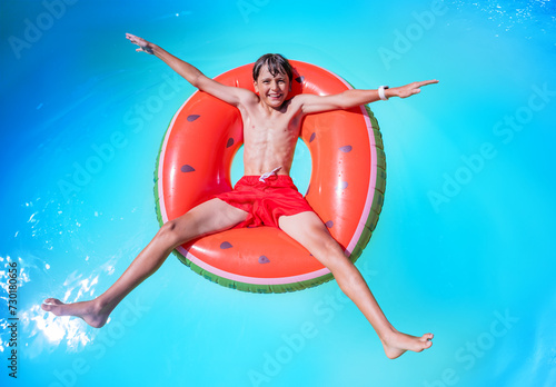 Young swimmer relax on big inflatable ring, in star shape pose