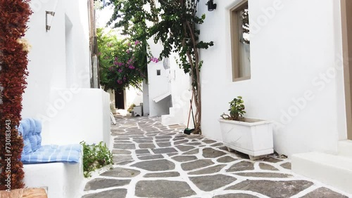 Naoussa typical white street leading to sea with sunshine, small village on Paros island, Greece photo