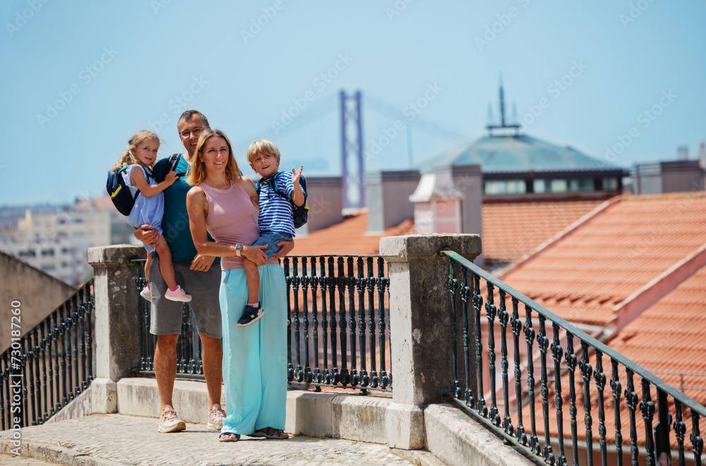 Happy family with kids enjoy Lisbon viewpoint in summer