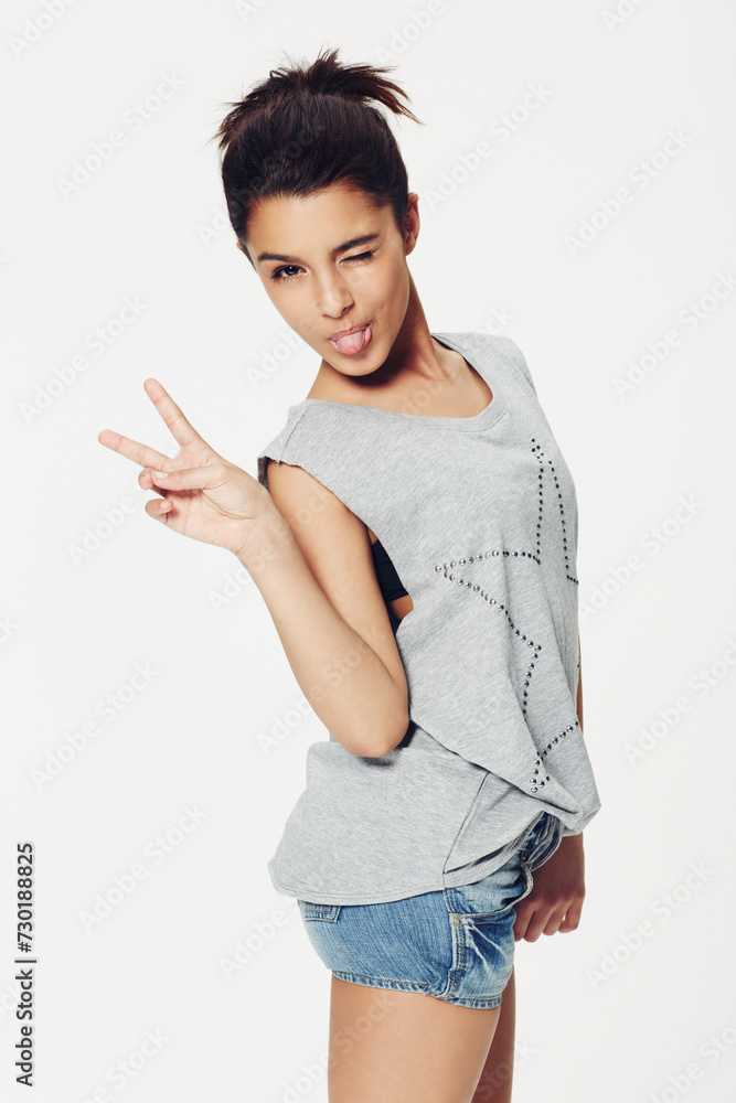 Portrait, woman and peace sign with tongue in studio for fun, playful and humour with confidence. Female person, emoji and face with gesture for pose, fashion or expression on white background Portrait, woman and peace sign with tongue in studio for fun, playful and humour with confidence. Female person, emoji and face with gesture for pose, fashion or expression on white background