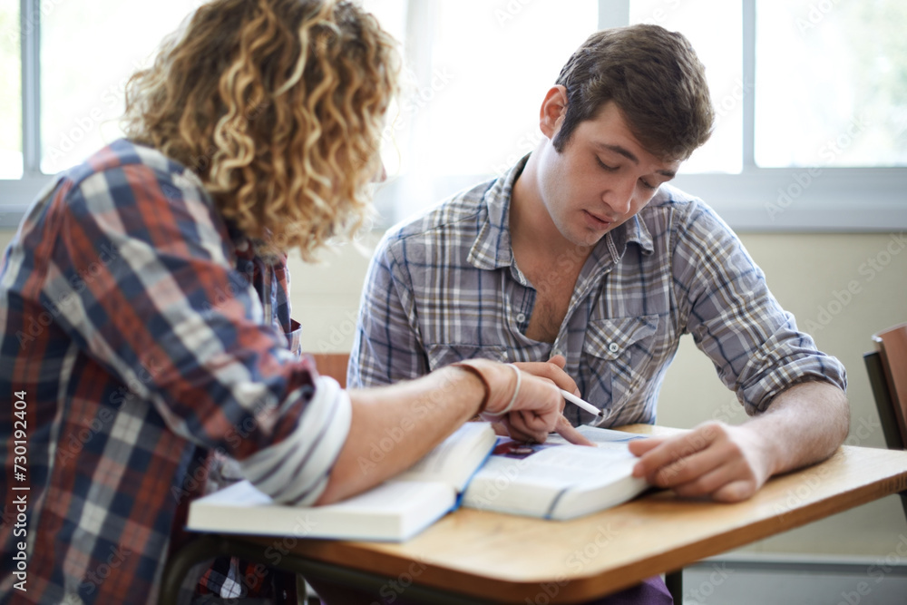 Students, reading and textbook with teamwork in university class for academic research, higher education or assignment. Men, friends and college campus for scholarship or exam, helping or studying Students, reading and textbook with teamwork in university class for academic research, higher education or assignment. Men, friends and college campus for scholarship or exam, helping or studying