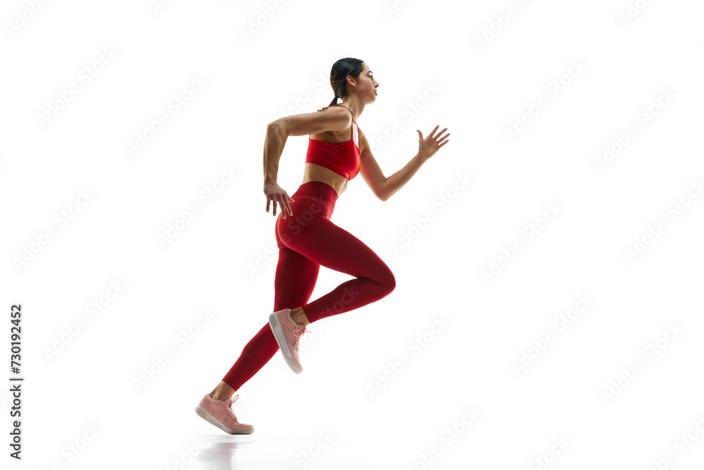 Dynamics, endurance and energy. Female runner athlete in motion, running, training against white studio background. Concept of sport, active and healthy lifestyle, sportswear, competition