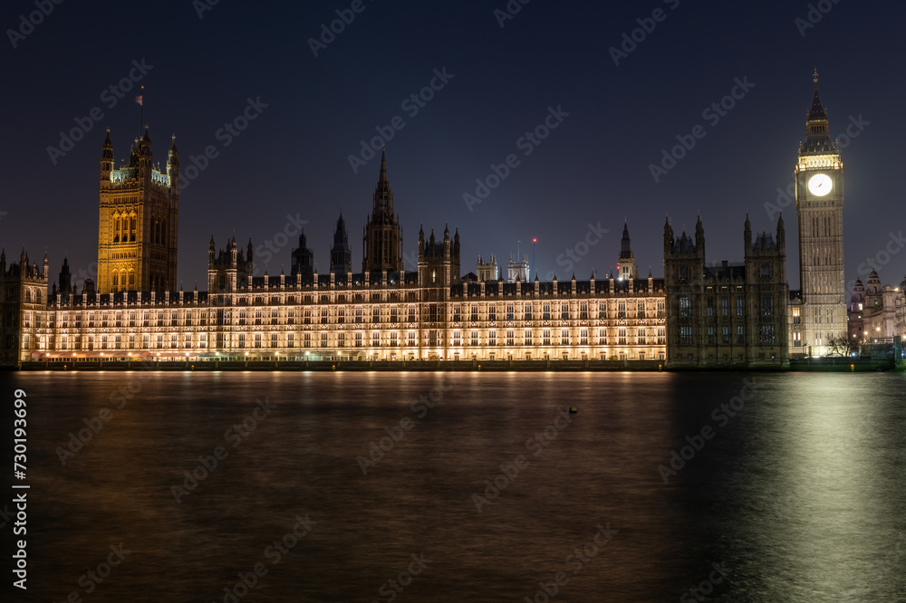 A night time view of the Palace of Westminster or House of Parliament and Big Ben from the south bank of the Thames river.