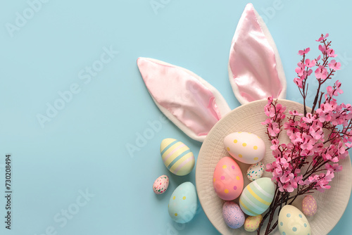 Happy Easter. Colorful easter painted eggs and pink almond blossoms  on a plate with space for text