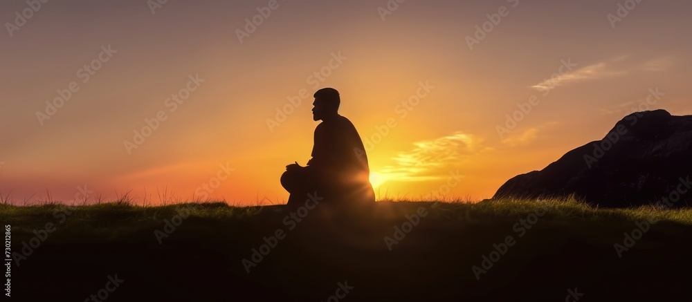 Silhouette of muslim man praying over sunset background.