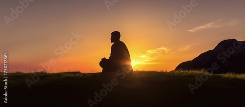 Silhouette of muslim man praying over sunset background. © andri