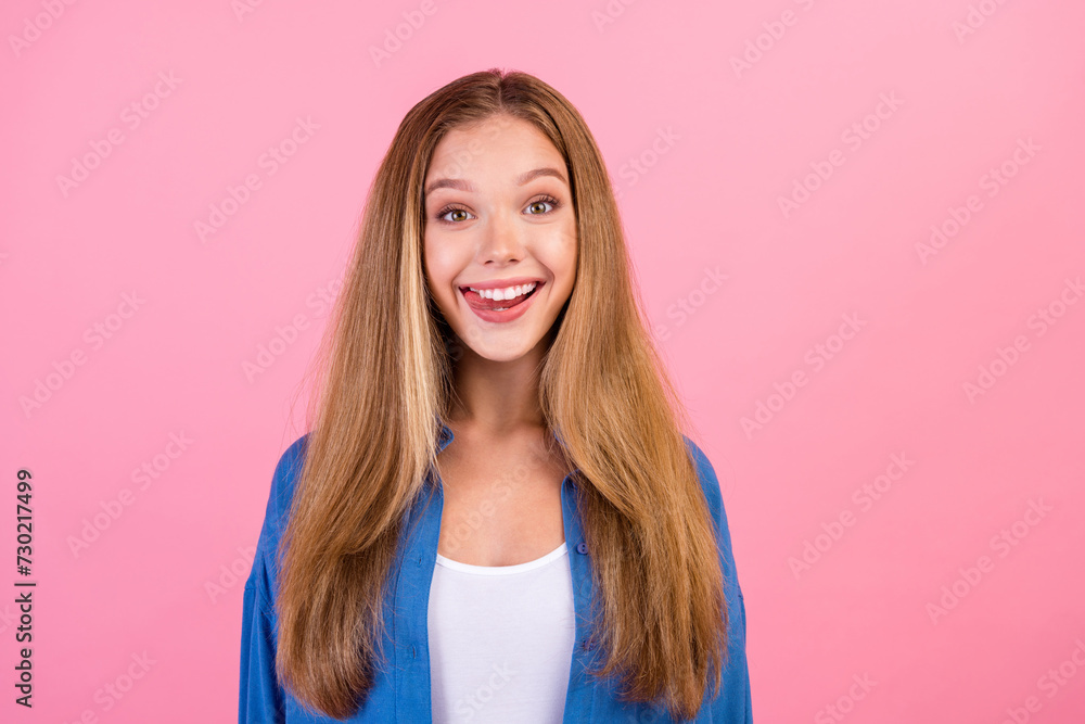 Photo of good mood tricky girl wear blue shirt stick out white teeth empty space isolated pink color background Photo of good mood tricky girl wear blue shirt stick out white teeth empty space isolated pink color background