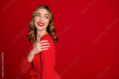 Profile portrait of lovely cheerful elegant girl hand touch shoulder look empty space isolated on red color background