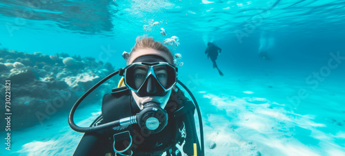 Female scuba diver, swimming underwater, pristine white sand under tropical sea clear blue, admiring Colorful coral reef, underwater and examining the seabed, snorkeling amongst many exotic fish