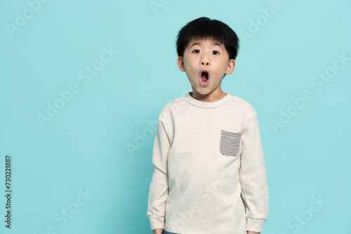 Asian little boy looked excited and looking at camera isolated on green background, Wow and screaming concept