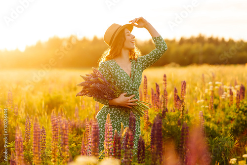 Beautiful woman stands on blooming fragrant lavender fields. Nature, vacation, relax and lifestyle. Collection of medicinal herbs