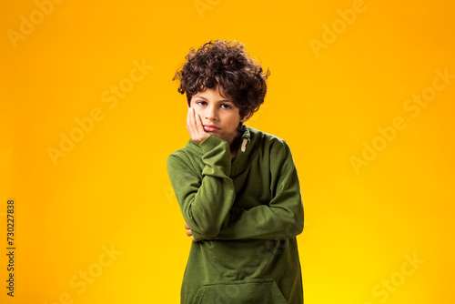 Smiling child boy over yellow background.