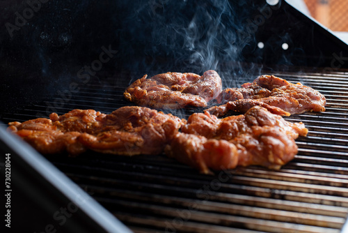 cooking a chicken in the grill in a party outdoors