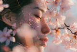 Portrait of beautiful woman feeling sakura blossoms of a tree in spring