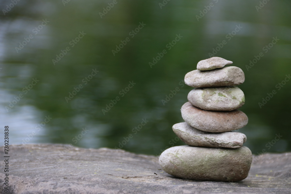 Balancepyramide aus Steinen am Fluss auf Felsen als Symbol von Stärke und Medidation