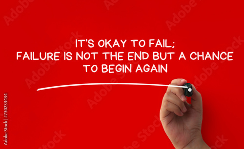 Hand writing It is okay to fail affirmation on red cover background. Affirmation concept. photo