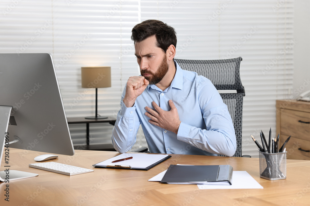 Sick man coughing at workplace in office. Cold symptoms Sick man coughing at workplace in office. Cold symptoms