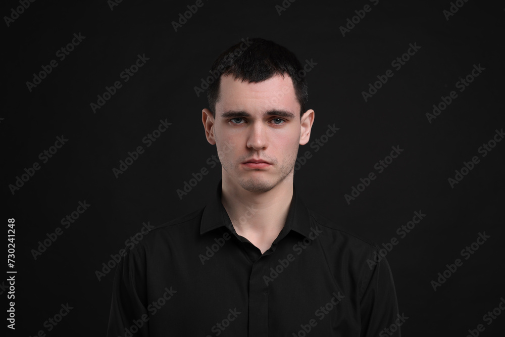Portrait of sad man on black background