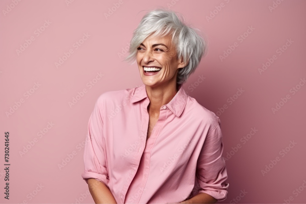 Portrait of a happy senior woman laughing against a pink background. Portrait of a happy senior woman laughing against a pink background.