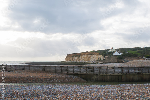 Stunning chalk cliffs overlooking the beach, with Coastguard lodges on top overlooking the English Channel and the breathtaking natural beauty of the famous white cliffs under the shining sun