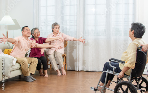 Selective focus on elderly people raising hands to hug friend who sitting on wheelchair to encourage, fighting with disease, smiling with happiness, sitting in nursing home. Retirement Concept.