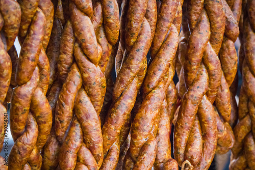 Fresh prepared smoked sausages with spices on market stall