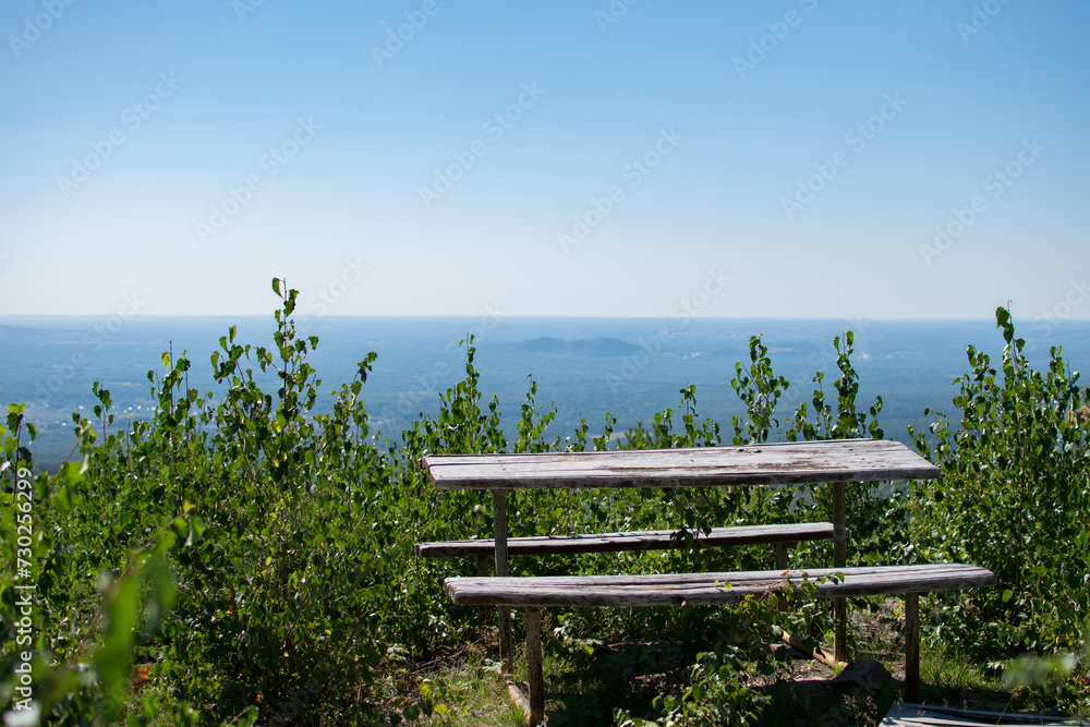 Obraz premium A place to relax at the top of the mountain on a summer day: a wooden table and two benches