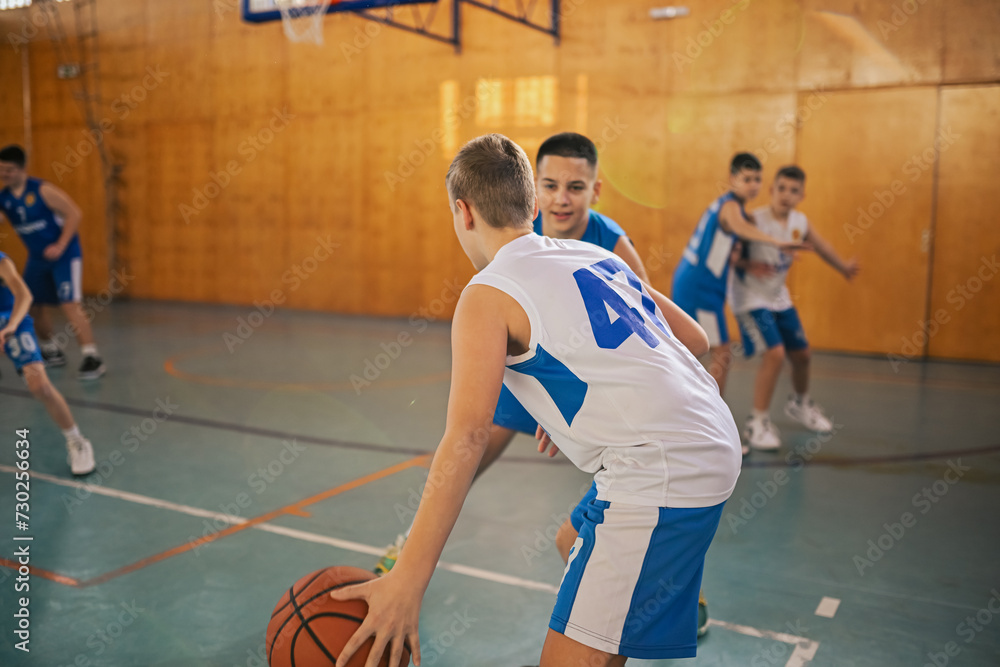 A young basketball team is practicing game strategy on training.