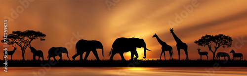 Late evening in the African savanna. Silhouettes of wild animals of the African savannah on the shore of a lake, against the backdrop of trees and the sun