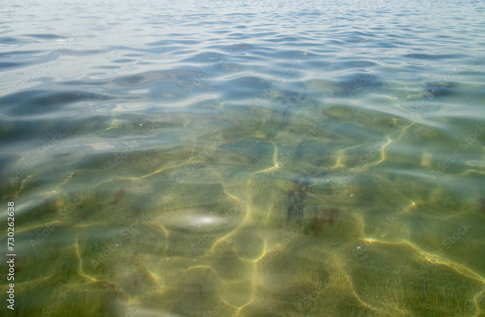 Abstract water surface of the sea with bubbles, reflections and green algae on seabed Abstract water surface of the sea with bubbles, reflections and green algae on seabed