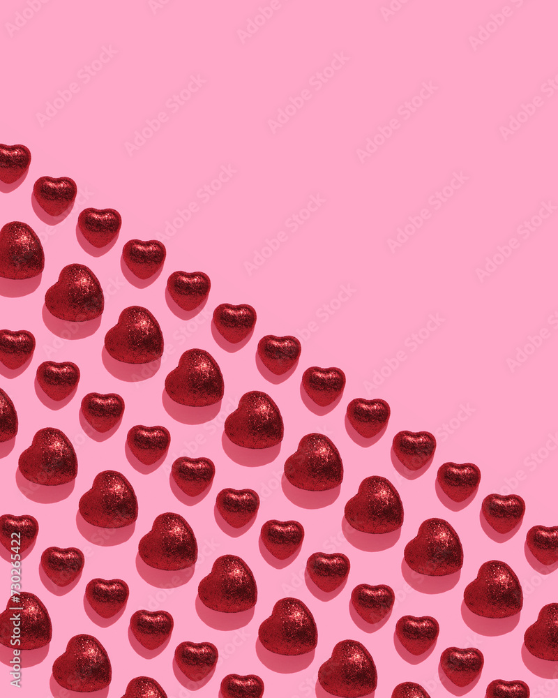 Vertical banner with geometric pattern of red glittery hearts on pink background. Valentine's Day card Vertical banner with geometric pattern of red glittery hearts on pink background. Valentine's Day card