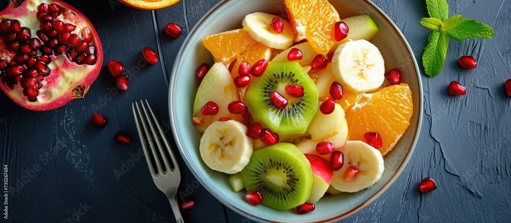 Bowl of fruit salad with orange, kiwi, apple, banana, and pomegranate seed is tasty. Bowl of fruit salad with orange, kiwi, apple, banana, and pomegranate seed is tasty.