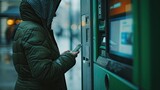 person using a mobile phone in front of a cash machine