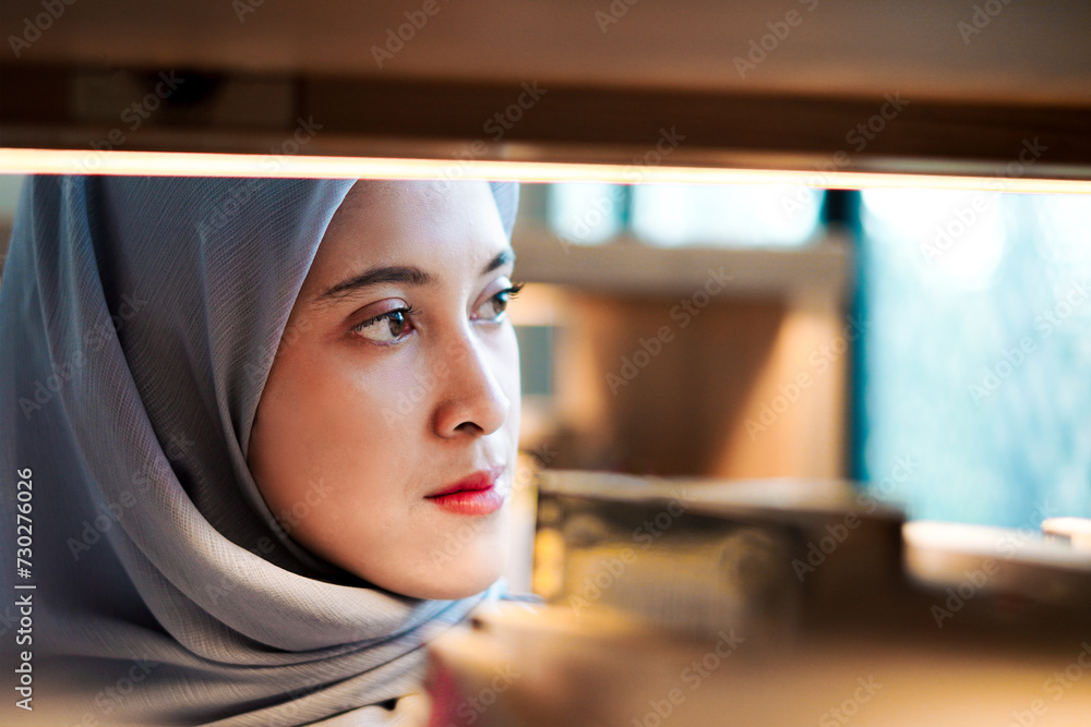 Asian muslim woman wearing hijab choosing & picking up book in bookshelf, education concept, reading learning studying in library. Asian muslim woman wearing hijab choosing & picking up book in bookshelf, education concept, reading learning studying in library.