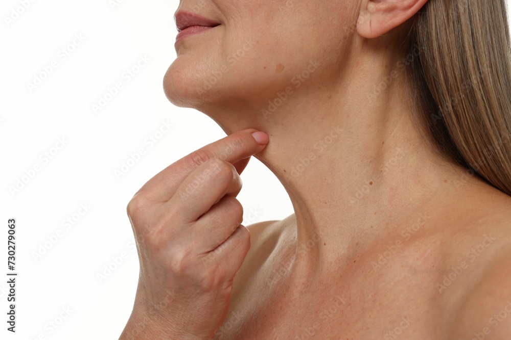 Obraz premium Mature woman touching her neck on white background, closeup