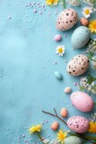 Decorative Easter eggs with spring blossoms framing a vibrant turquoise background with copy space.