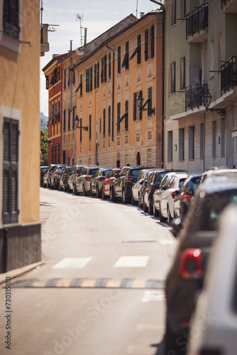 Cars parked on the beautiful street in a historical part of the city. Urban transportation infrastructure concept. Liguria, Italy. 