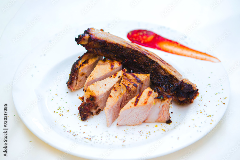 Roasted pork ribs and carrot on white plate Roasted pork ribs and carrot on white plate
