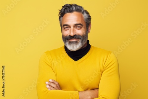 Portrait of handsome bearded man in yellow sweater, isolated on yellow background
