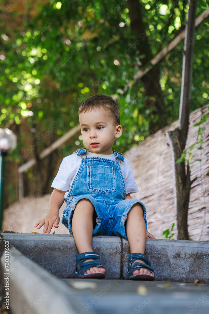 Little boy is sitting on the steps in the park. Little boy is sitting on the steps in the park.