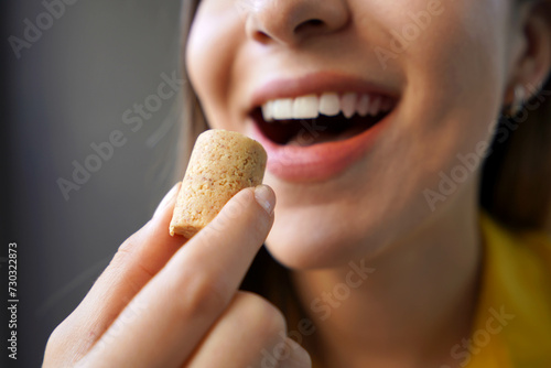 Peanut candy  pa  oca or pacoca . Extreme close-up of beautiful girl eating Pacoca traditional Brazilian peanut-based candy.