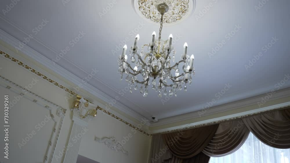 In the building, a wooden ceiling fixture hangs from the molding In the building, a wooden ceiling fixture hangs from the molding