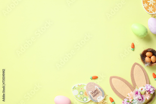 Flat lay composition with Easter eggs, bunny ears, decorations on pastel green background. Happy Easter concept.