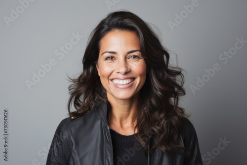 Portrait of a smiling woman in leather jacket looking at the camera