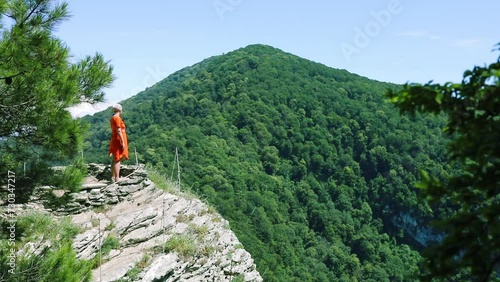 Happy woman looks at green mountains at sunny day, Eagle rocks, Sochi, Russia, slow motion photo